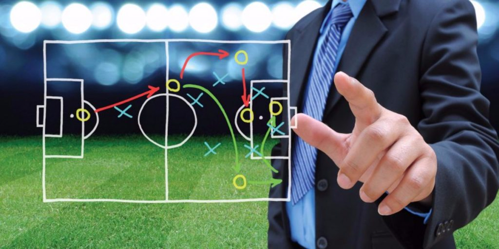 Man dress in suit behind the soccer game plan